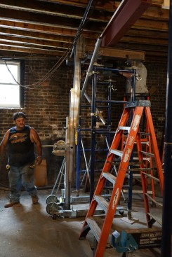 With the lift holding the first section in place, shoring is erected below the beam. At this stage, the beam is slightly low to allow the crew to move it laterally into a beam pocket in the far wall of the basement. 