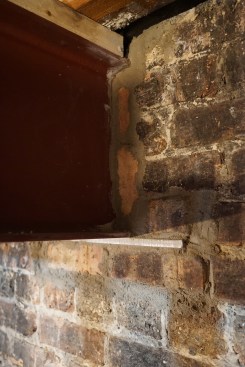 Grouted into the wall after the columns were set, the beam bears on a steel plate. Note the top plate on the beam installed with powder-actuated fasteners prior to lifting.