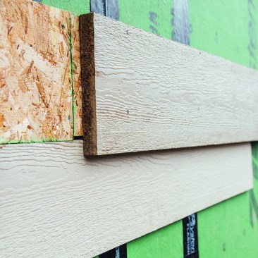 Ribbon boards serve as a visual element that helps define gable ends. Here, the author packs out a trim board with OSB ripped narrower than SmartSide Trim boards so the bottom edge of the ribbon overlaps and protects the siding board below it.
