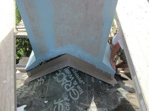 A cricket in the plane of the roof creates positive drainage away from the chimney. Use plenty of peel-and-stick on the cricket, lapping it onto the chimney and sealing its top edge with mesh and a liquid WRB.