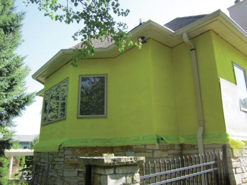 Through-wall flashing is needed at the transition from stucco to another type of siding, be it synthetic stone, vinyl, or fiber-cement. In this project,  W.R. Grace Perm-A-Barrier wall membrane (the green membrane at the base of the wall) was used. The top edge of the through-flashing is adhered to the wall and sealed with mesh and liquid WRB. 

