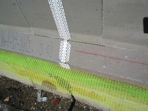 Vertical control joints should completely divide the wall section. Bring the joint right through any transition at the wall base.
