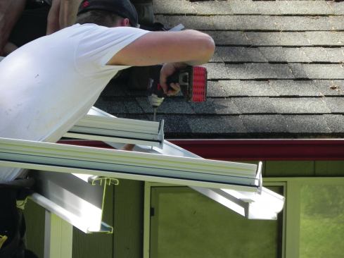 Gutters are included in the patio-cover kit and are screwed to the lower end of the T-bars. Here you can also see the T-bar end caps, which help hold the glazing panels in place.