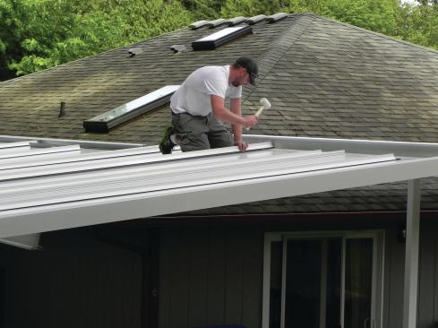 Finally, gasketed T-bar caps are carefully hammered into place over the tops of the T-bars using a rubber mallet.