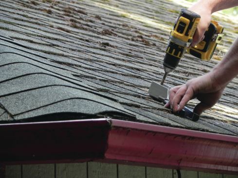 A post-bottom shoe that has been modifed to fit the slope of the roof is bolted to framing or solid blocking.