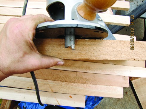 Figure 15. Hold the router in place to set the depth of cut for half-lap joints. 