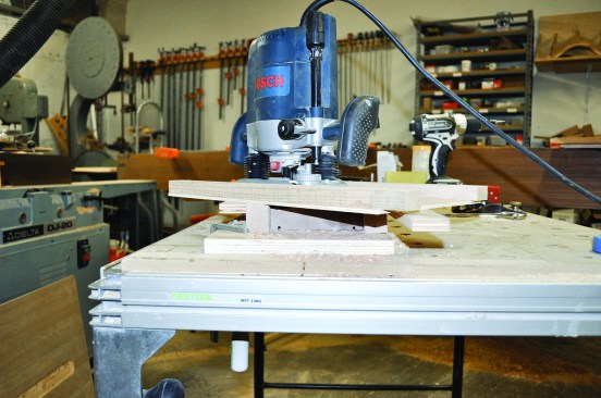 Figure 20. A second jig atop the first guides the router to make an angled lap cut on profiled stock.