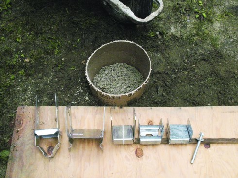 Figure 7. A variety of post bases are available that both tie down the post and raise it above the footing to keep the end grain dry and rot-free. 