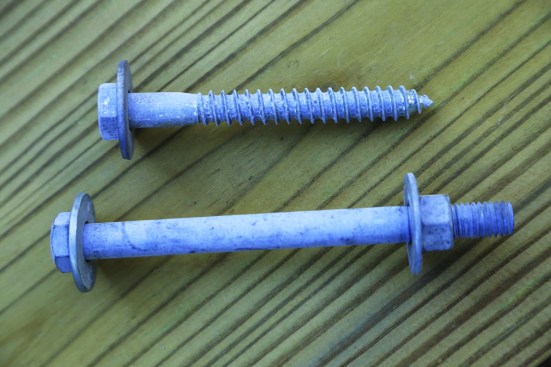 Hex-head 1/2-inch hot-dipped galvanized bolts and 1/2-inch lag screws with standard cut washers are the only two fastener options listed in the IRC for attaching deck ledgers.
