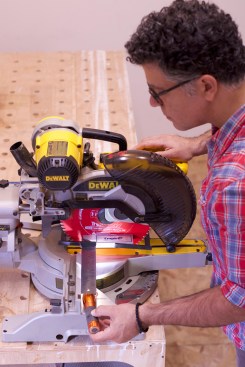 With the saw’s head set at the 90° detent, clamp the try square to the saw blade so that the square can register near the top of the fixed fence. A flashlight will help identify even the tiniest gaps here.