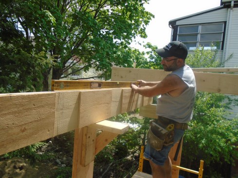 PT plywood or PVC spacers can be used to create drainage gaps between the 2-by layers of a built-up beam, preventing water from being trapped between doubled framing members.