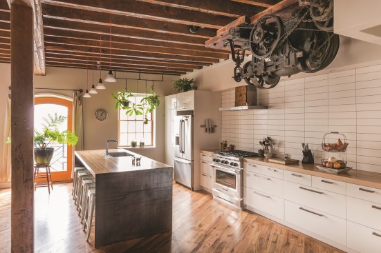 Motor and gears from te elevator hang over the kitchen prep area for a unique conversation piece