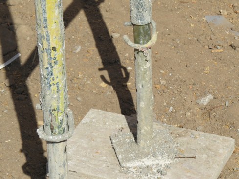 Pins for the base plates shown in this example need to be placed into the holes provided; the pin in the foreground in image is correct, but the pin at rear, set underneath the pipe, is a violation that has been known to cause failures and injuries.