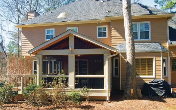 This home’s full two-story wall design and small upper-floor windows allow a simple wall tie-in for the porch addition’s gable roof.