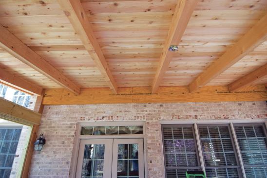 When working with brick veneer, the author hangs the porch rafters from a structural double LVL ridge beam (shown before hanger installation).