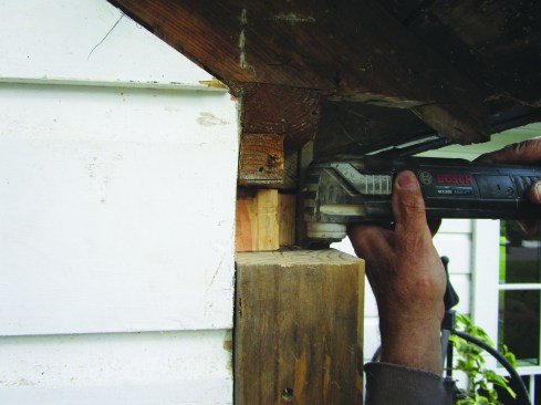 After removing the trim at the house corners and eaves, the author used a multitool and sharp chisel to cut pockets in the solid 4x6 corners for the beams that would support the new portico roof.