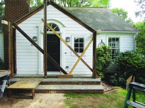 To accurately lay out and support the triple 2x6 beams and 2x8 ridge, he installed vertical posts and diagonal bracing fastened to a temporary plate on top of the new masonry stoop.