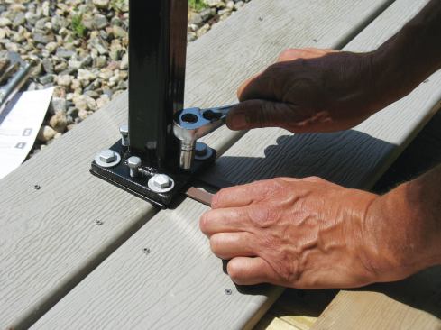 Anchor bolts drop through the holes at the corners of the base of the Secure-Mount, while the smaller holes in the edges are threaded for the adjusting screws that are used to plumb the post.