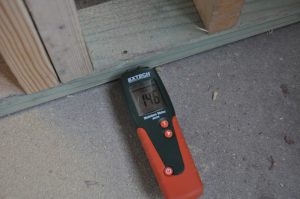 Pressure treated bottom plate on a concrete slab reading 14.6% MC