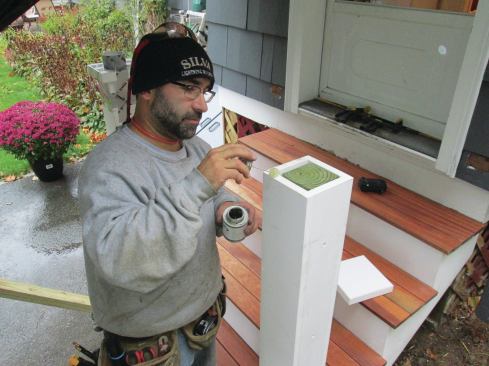 The post caps were made of a double layer of PVC, and were glued to the tops of the post wraps. The author used masking tape to hold the caps in place while the glue cured.