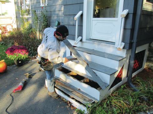 The author removes a tread from the original stair.