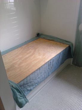 The tub is protected by a moving blanket and a tightly fitted piece of 5/8-inch plywood.
