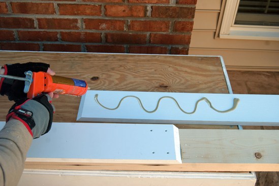 To lock a PVC joint in place, the author begins by gluing the trim to the substrate with construction adhesive.