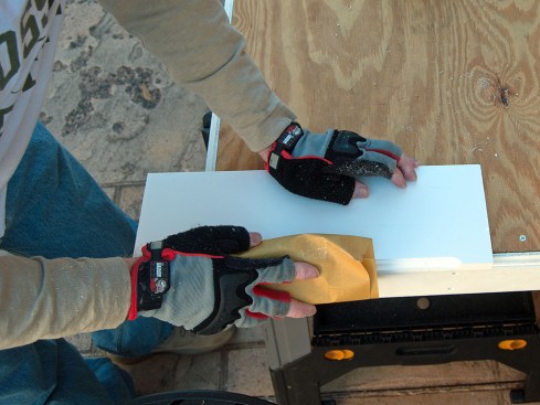 After cutting or routing PVC trim, the author gives the cut a light sanding with 320-grit paper.