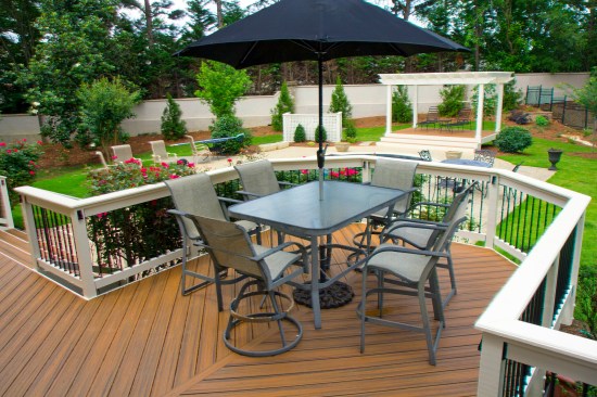 This deck features a PVC rail-cap with a custom edge profile, cut on site with a router. Though most decking manufacturers offer  trim options to match their decking, PVC trim provides an alternative contrasting look that can be left unpainted (depending on manufacturer) or painted to match the house trim. Some PVC trim is manufactured with a wood grain texture on one side and a smooth surface on the other. 