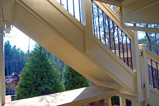 Here, trim ripped from a 4x8 sheet of PVC was attached to the underside of the stair stringers to divert rain away from the stone bar top underneath. 
