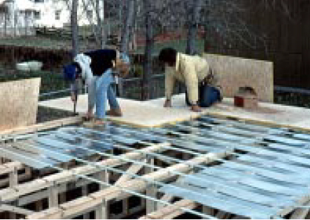 In a below-deck dry system, the aluminum plates wrap around the underside of the tubing. In new construction (top), the tubing and plates can be installed before the subfloor.