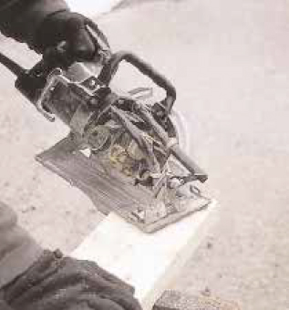 Leaving the line visible on the board, he then cuts along the outside line with the saw set at a 45-degree bevel, moving from the top edge of the rafter towards the bottom to cut the long point.