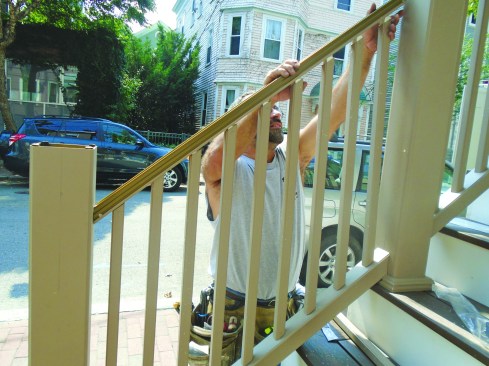 Balusters are next. Then he snaps the upper beam in place.