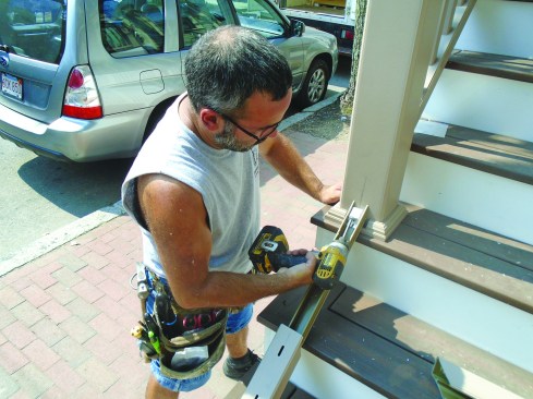After making a small cutout in the trim ring for the beam, the author fastens it to the posts.