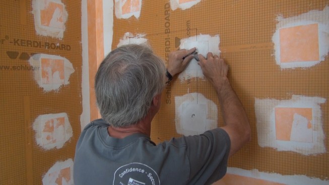 Boucher pulls the washer away from the wall.