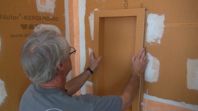 Boucher places the box in the opening temporarily. He still has to cut out the opening for another box right next to this one.