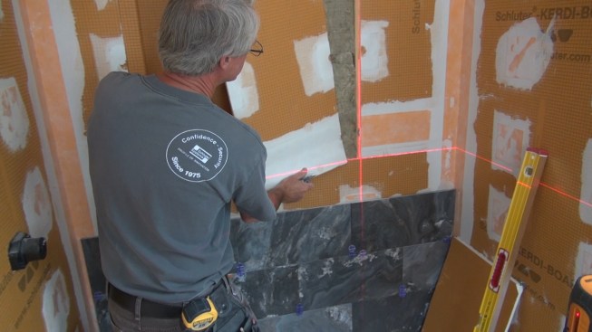 Boucher removes the section of Kerdi-Board from the location where the second box will be installed.