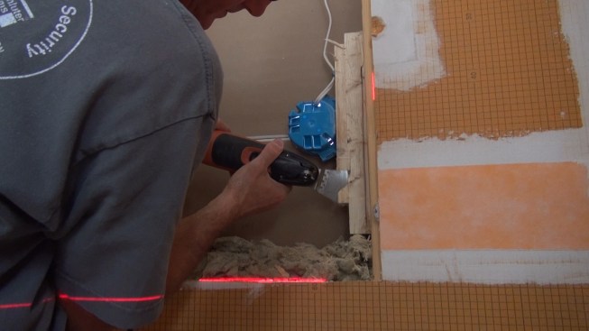 Because the space is quite tight, Boucher has to carefully trim away the edges of the block with a Fein Multimaster.