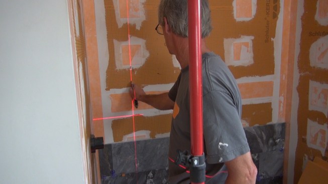 Bouchet probes with a razor knife to locate the edge of the wall stud behind the Kerdi-Board.