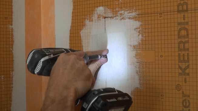 Boucher removes the screw from the existing washer.