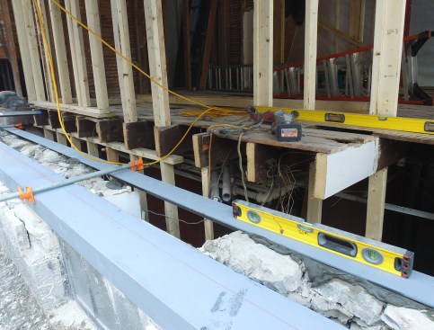 Continuous lengths of angle-iron, bedded in grout, are clamped together along the deteriorated section of the foundation.