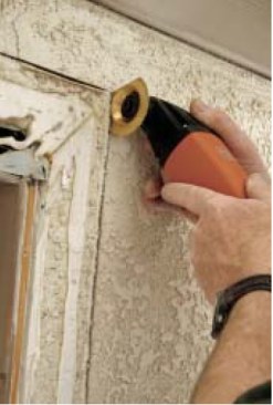 He finishes the ends of the cuts with a multitool equipped with a masonry blade, keeping the cuts shallow enough to avoid hitting the building paper.