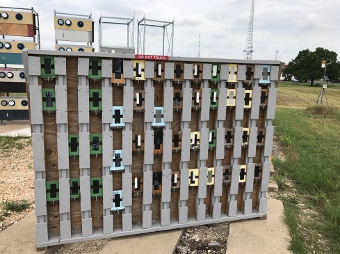 Test rack showing tapes in tension with a small weight attached to see how well they stick given stress. It’s no accident that most of these on the rack are acrylic based as the Asphaltic & Butyl based tapes have fallen off already.