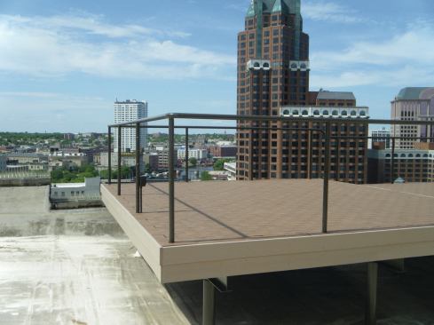 This deck was finished with a traditional two-tier fascia, which locks the pavers in place. The pavers were also glued to the installation grid to counter wind uplift.