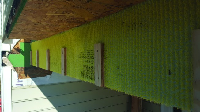 We installed Home Slicker, a matrix-type rainscreen, to the exterior side of the beam. Then we then installed 2-inch-wide strips of 3/4-inch marine plywood before attaching a 2x8 band.