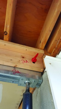 The top support beam is made with light-gauge steel that fits into an upside-down-U pocket consisting of a 2x12 plate and two 2x6s on edge. We drilled slots in the 2x6s and a hole in the steel beam for a pin, which allowed for adjustments in height.