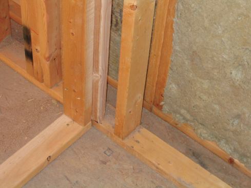 My double-wall assembly, with an outer and an inner 2x4 wall separated by a 3 ½-inch space. Staggering butt joints from course to course, I placed the first and third layers vertically and the middle layer horizontally.