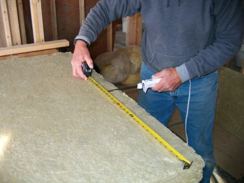 I created a cutting table by stretching a couple of plywood rips over sawhorses and simply ran the electric knife down the middle. For narrow pieces, I hung one edge of the batt beyond the plywood, and carved off what I needed.