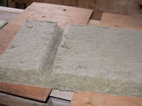 Squeezing any fibrous insulation behind electrical boxes is not a good idea, so we cut around the boxes. For wires, we scored the Roxul and inserted the wires into the grooves. For plumbing pipes, we made a V-groove to accommodate each one ...