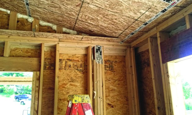 A horizontal strip of OSB at wall-plate height tied the inner wall frame to the outer frame.